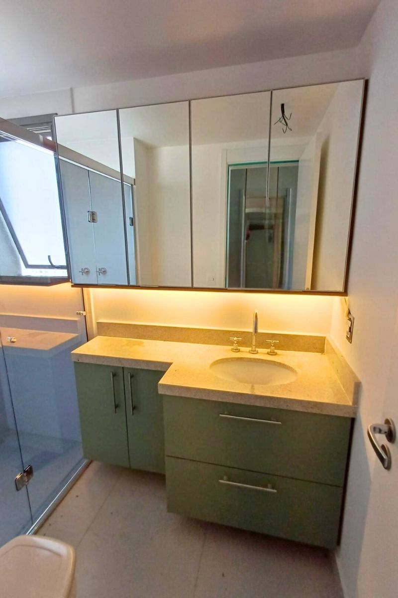 Banheiro planejado com armários brancos e nichos decorativos