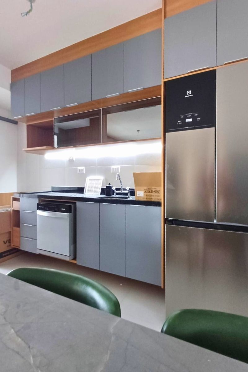 Cozinha planejada em MDF cinza moderno, com nicho exato para lava-louças e geladeira duplex em aço inox.