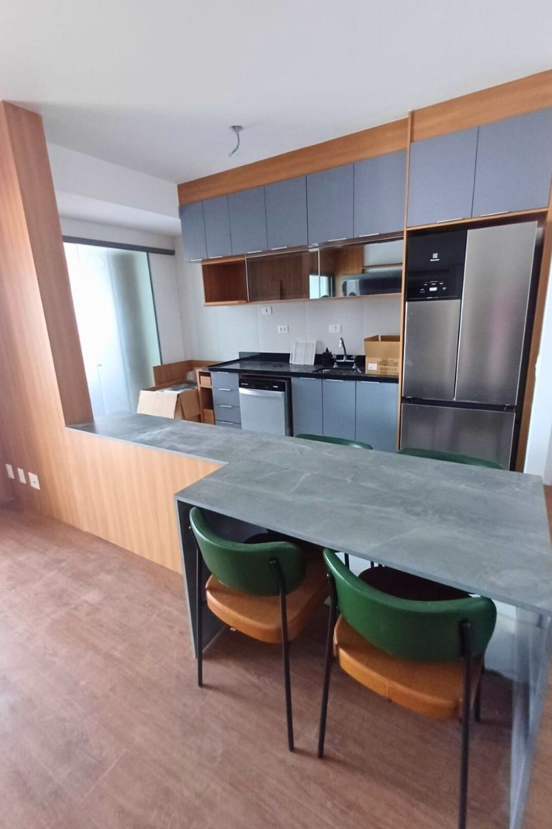 Cozinha americana com conceito aberto, apresentando balcão de refeições (península) e integração com a sala.