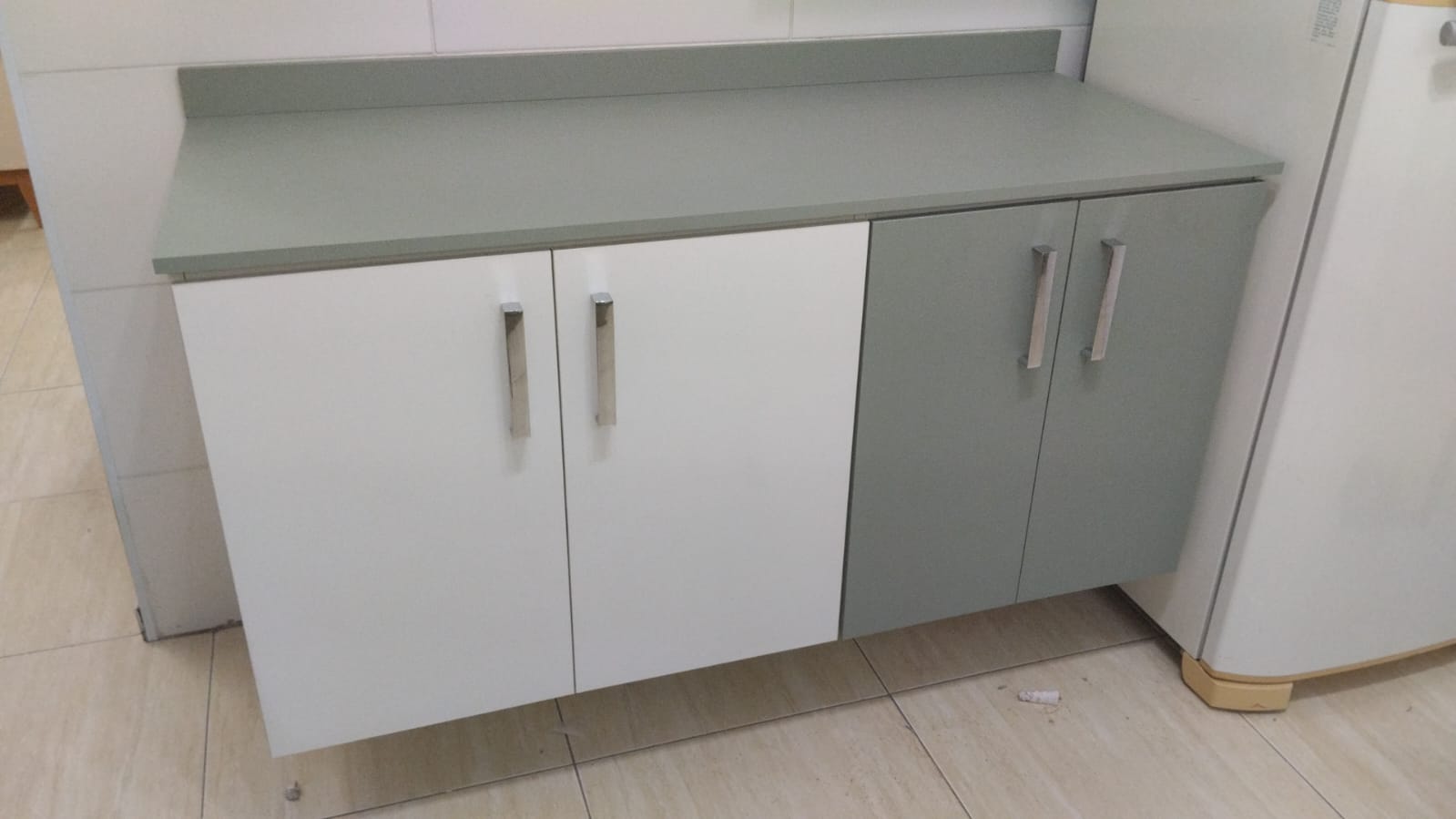 Cozinha gourmet planejada de alto padrão com ilha central, armários brancos e estrutura metálica suspensa (estilo industrial).