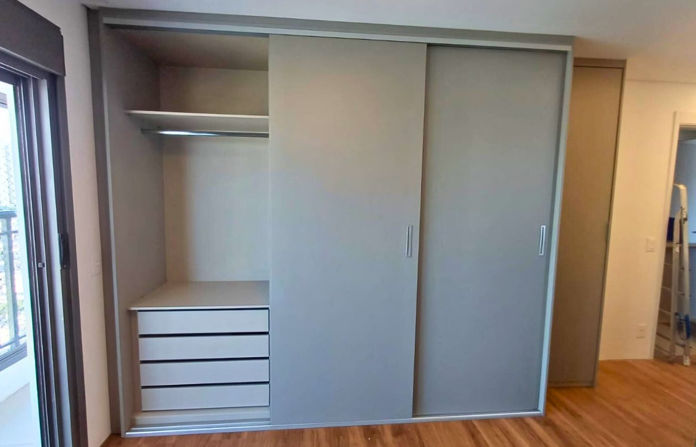 Interior de guarda-roupa planejado com cabideiros, gavetas e prateleiras organizadas, mostrando a divisão interna funcional.