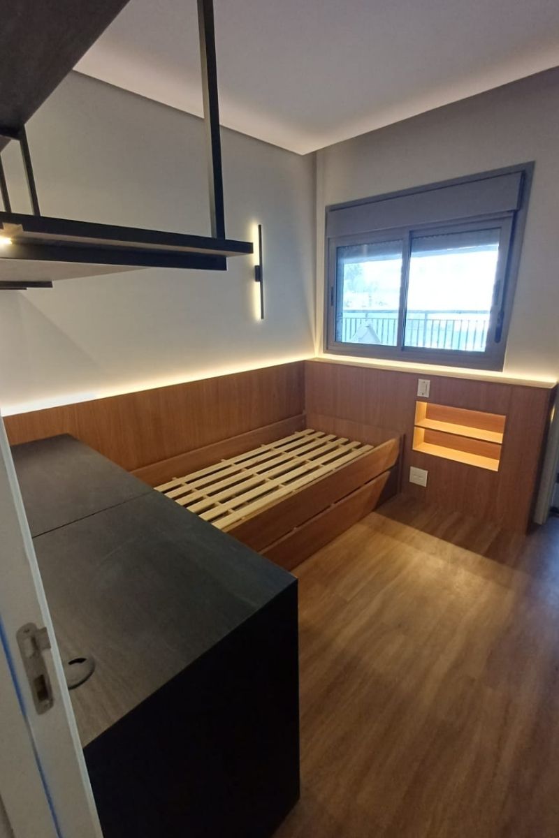 Cama de solteiro planejada estilo plataforma em madeira, com cabeceira em L, nicho lateral embutido e iluminação LED indireta aconchegante.