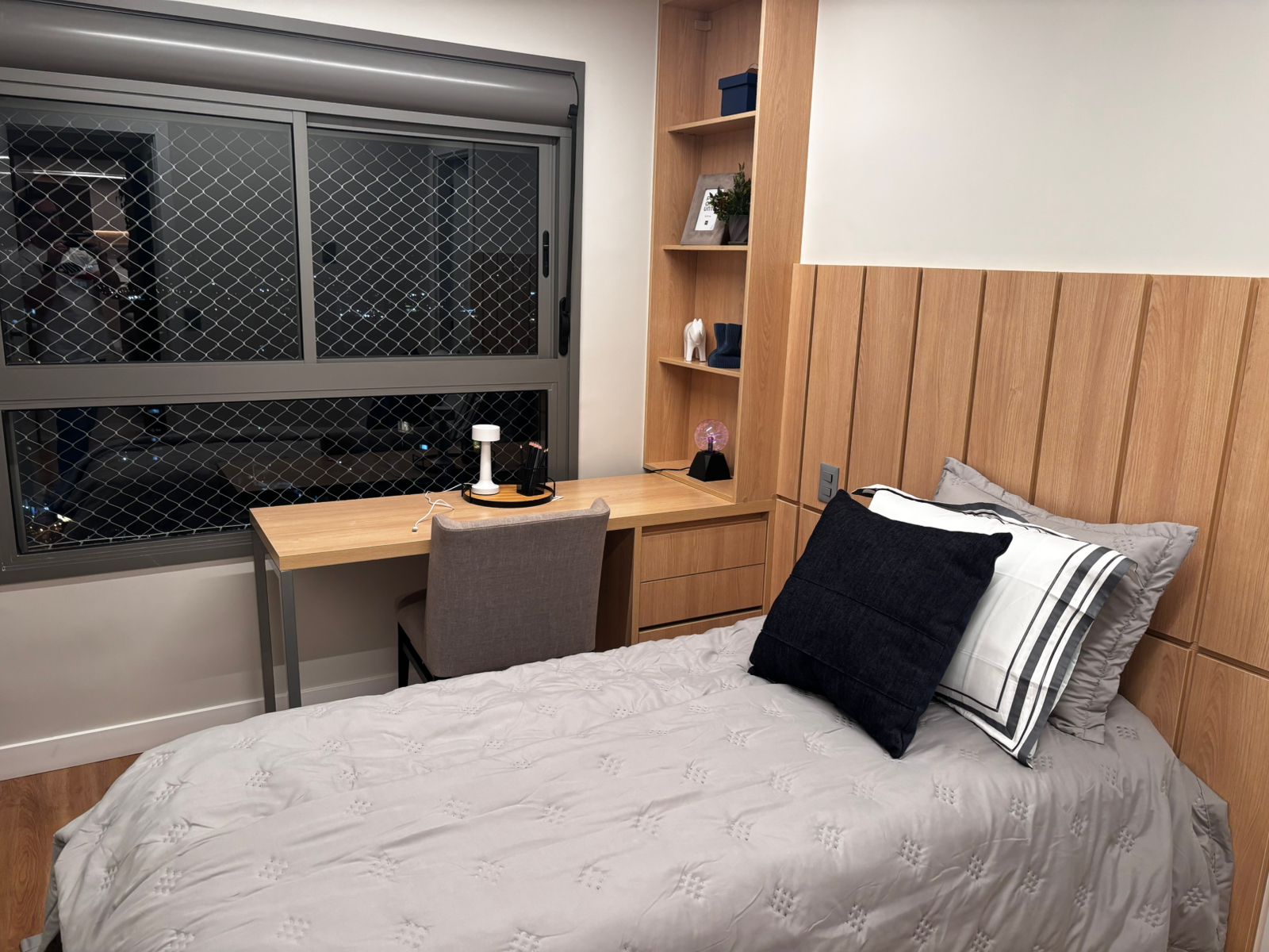 Projeto de dormitório com móvel para TV em tom verde menta, gavetões espaçosos e guarda-roupa com portas espelhadas bronze.