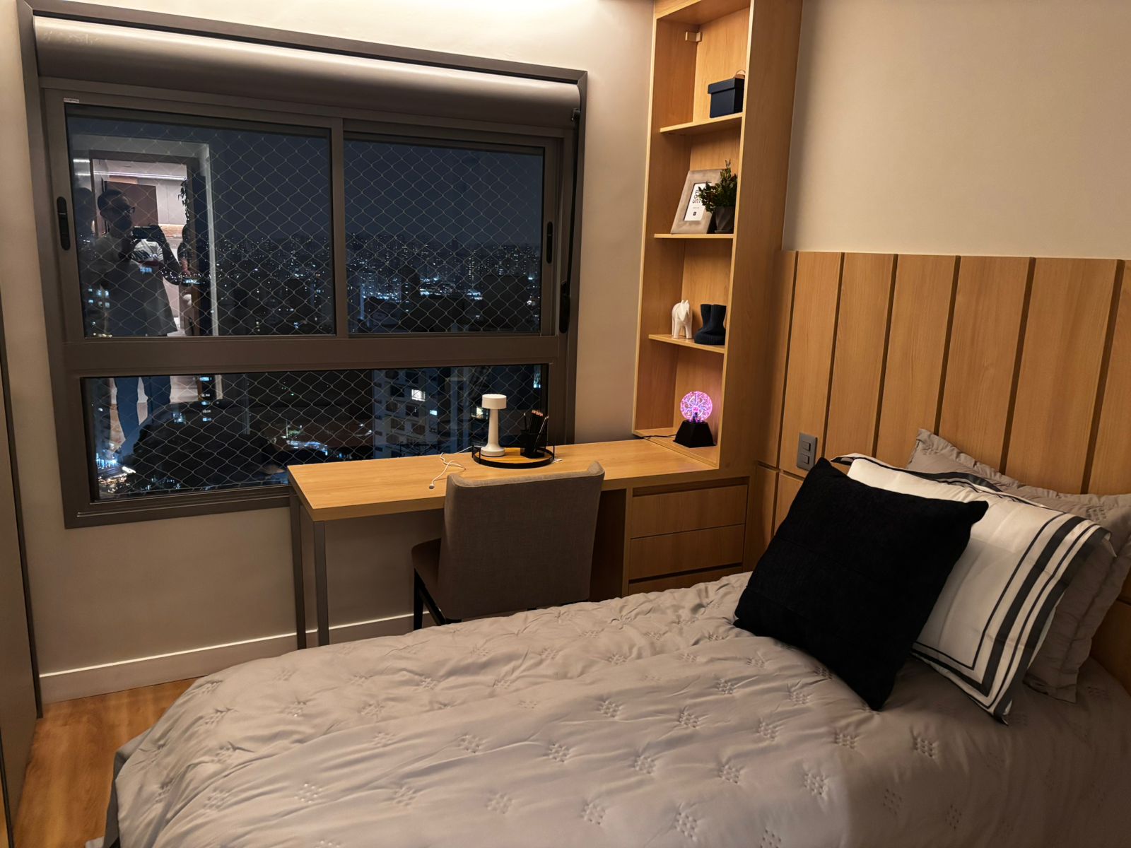 Detalhe de armários aéreos planejados sobre a cama, otimizando o espaço vertical em quartos pequenos.