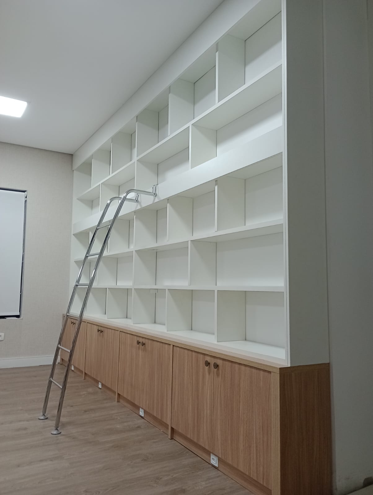 Vista interna de guarda-roupa planejado aberto, exibindo prateleiras e cabideiros para organização de roupas.