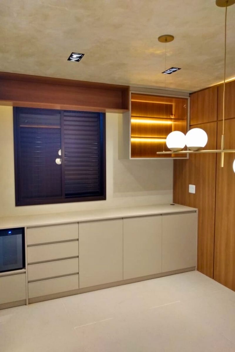 Bancada de quarto ou penteadeira planejada com iluminação LED quente, espelho e armários em tom neutro.