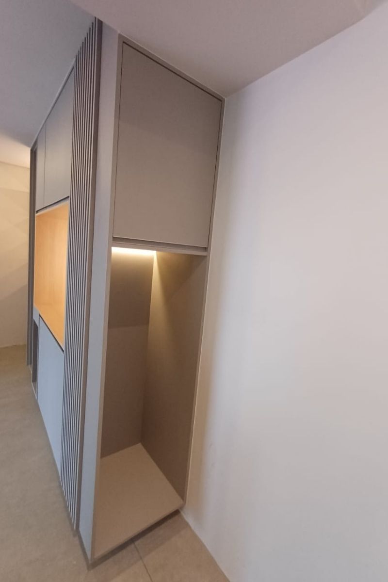 Armário planejado aberto (closet) com cabideiros e iluminação LED interna para organização.